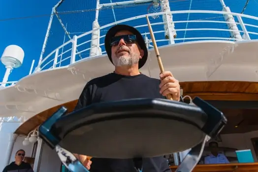 Musician leading a drumming workshop on deck